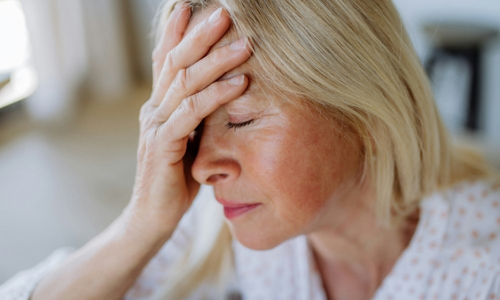 ASA (31) A blonde woman with her eyes closed holds her hand against her forehead in a gesture of stress or headache.